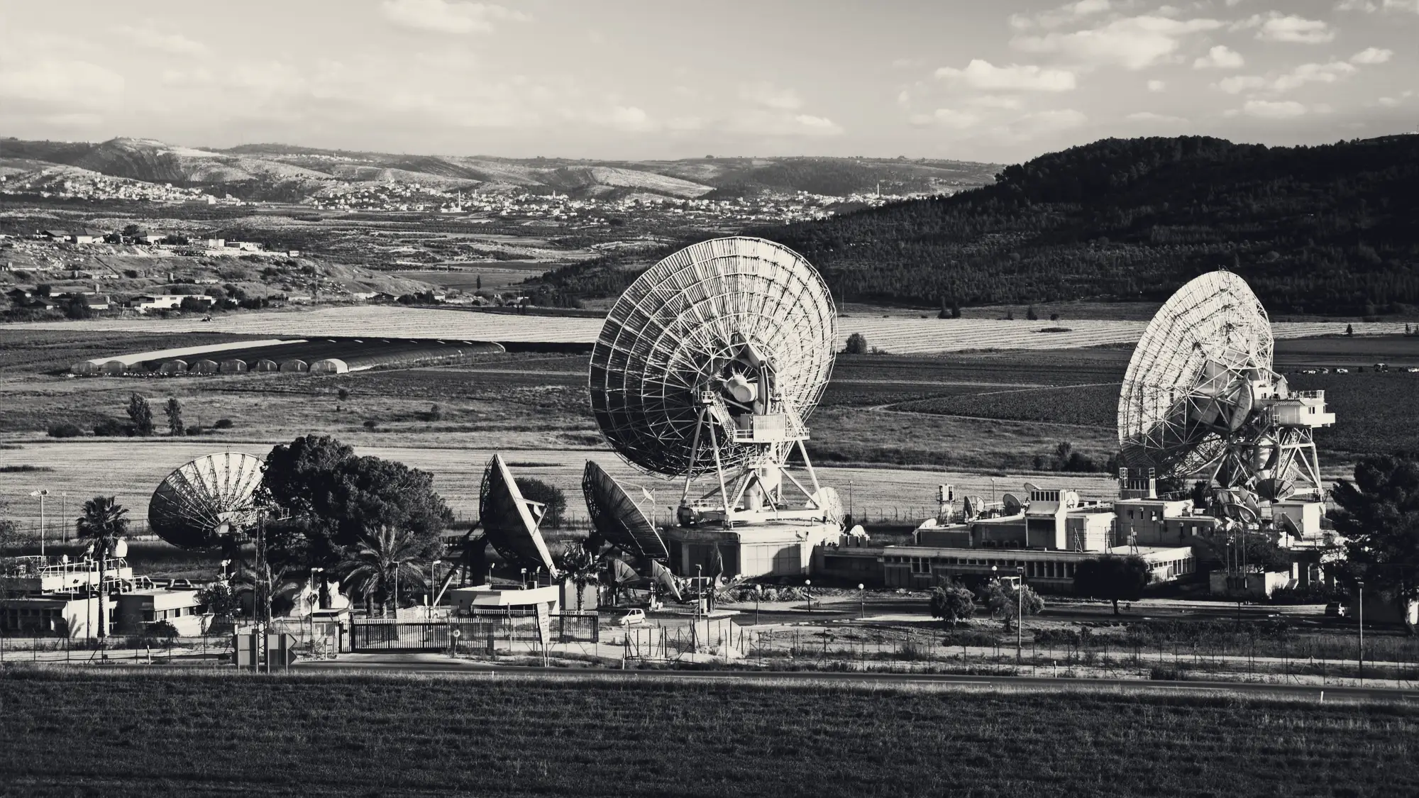 Satellite dishes across a green valley